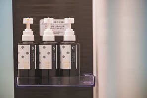 A display of four bottles of body soap labeled B, S, and C, each with a pump dispenser.
