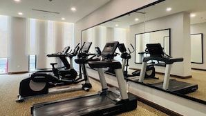 A hotel gym with treadmills, ellipticals, and a mirrored wall. - Vinhomes Sky Lake Luxury - Chup Housing  (Hanoi)