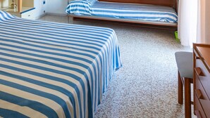 A room with two beds, a wooden desk, and a small chair. - Marchioretto Apt. - * Beach place and Parking * (Jesolo)