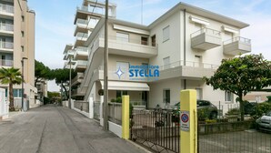 A multi-story residential building with balconies, a gated entrance, and a sign for 'immobiliare STELLA'. - Marchioretto Apt. - * Beach place and Parking * (Jesolo)