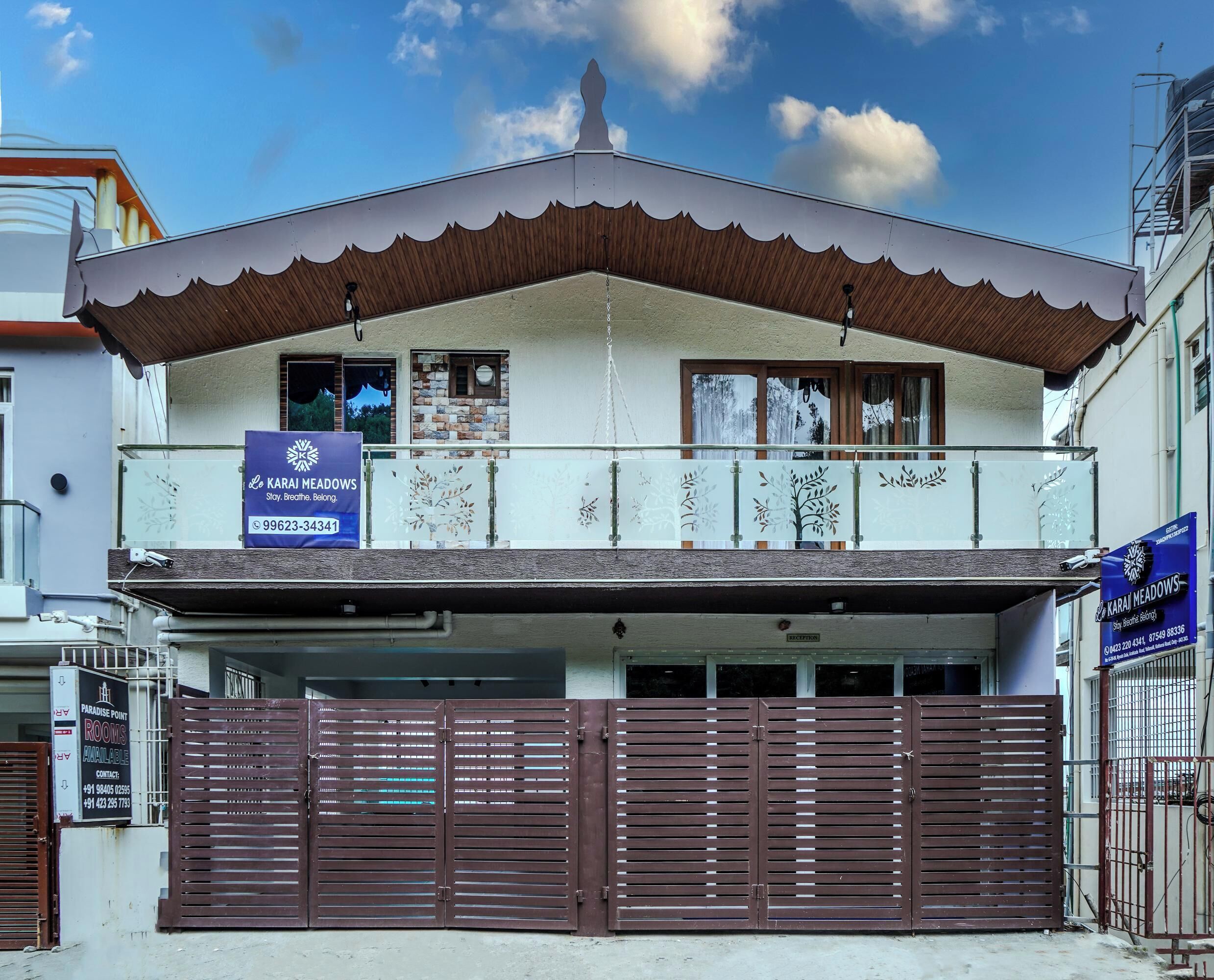 Edifici de dues plantes amb un balcó, i un rètol que anuncia 'Paradise Point Rooms' juntament amb un número de contacte.
