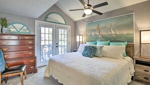 A bedroom with a bed, dresser, and a ceiling fan.
