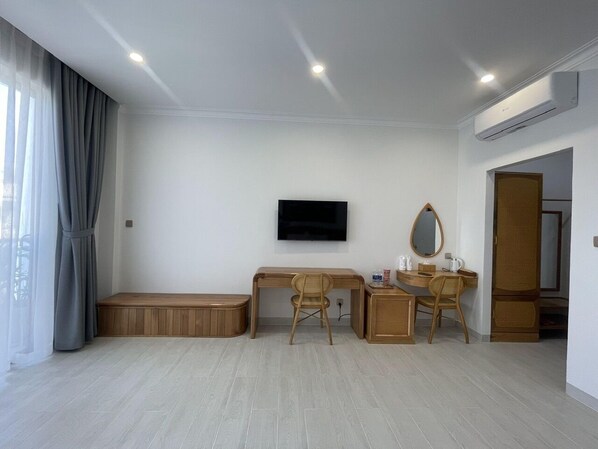 Ein modernes Zimmer mit einem Holztisch, zwei Stühlen, einem Fernseher und einer kleinen Bank.