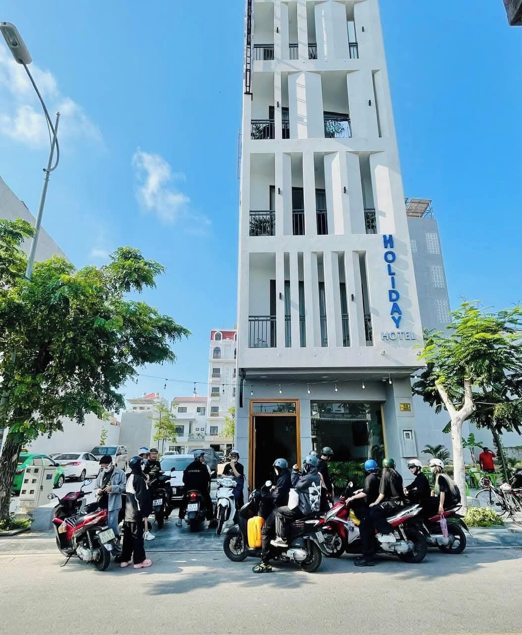 Un moderno edificio de hotel con balcones y un letrero que dice 'HOLIDAY HOTEL'.
