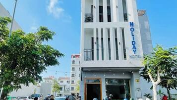 Un moderno edificio de hotel con balcones y un letrero que dice 'HOLIDAY HOTEL'.