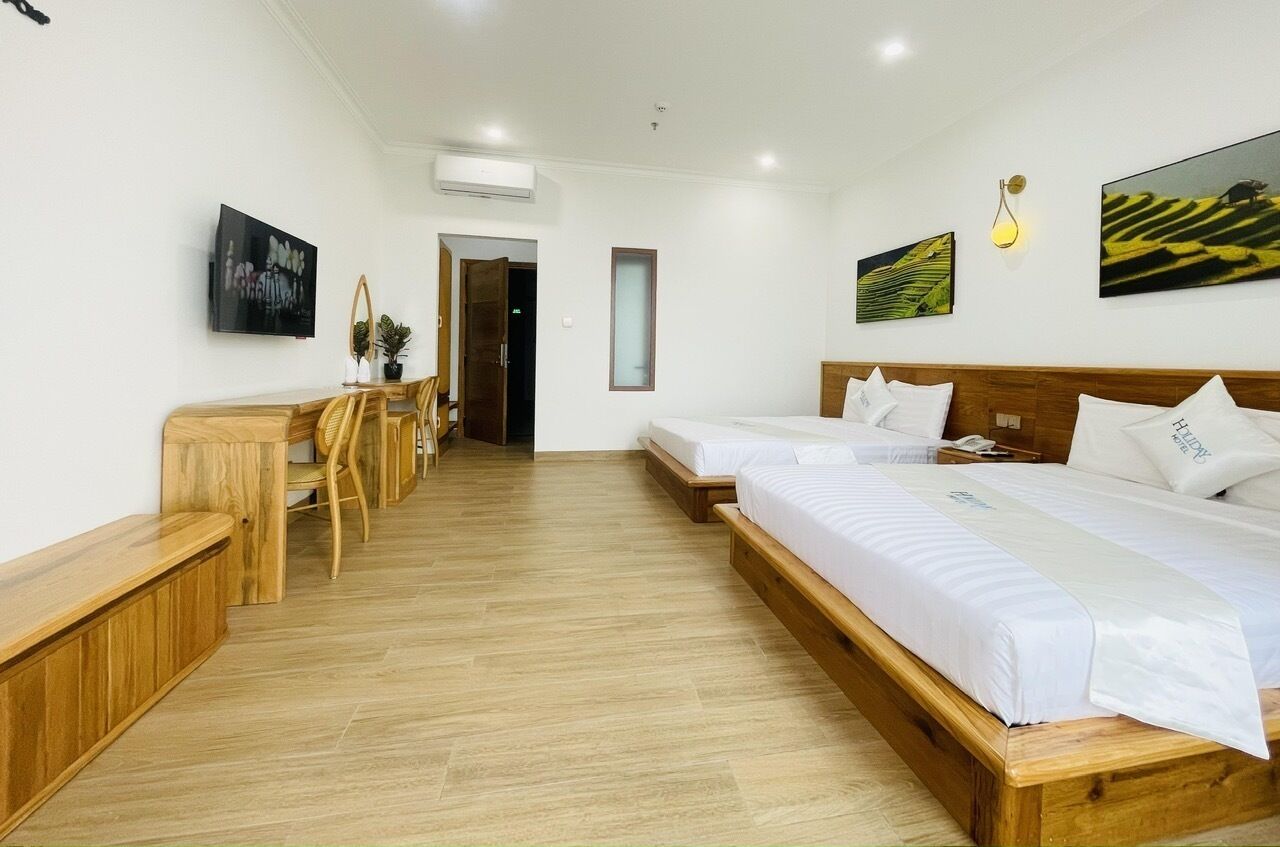 Ein Hotelzimmer mit zwei Betten, einem Schreibtisch und einem Stuhl.