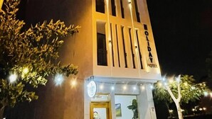 Un hôtel à plusieurs étages, doté d’un design moderne, avec une entrée imposante et une enseigne indiquant qu’il s’agit d’un hôtel de vacances.