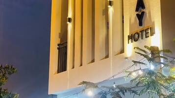 A building with a sign reading 'HOLIDAY HOTEL' and a circular sign with the word 'HOLIDAY' on it.