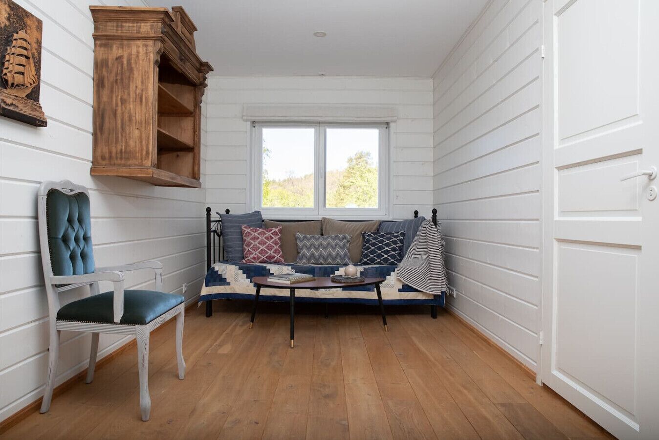 Een gezellige hoek met een comfortabele bank, een stoel en een houten plank.