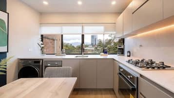 Una cocina moderna con lavadora integrada, un ventanal y vistas de la ciudad.