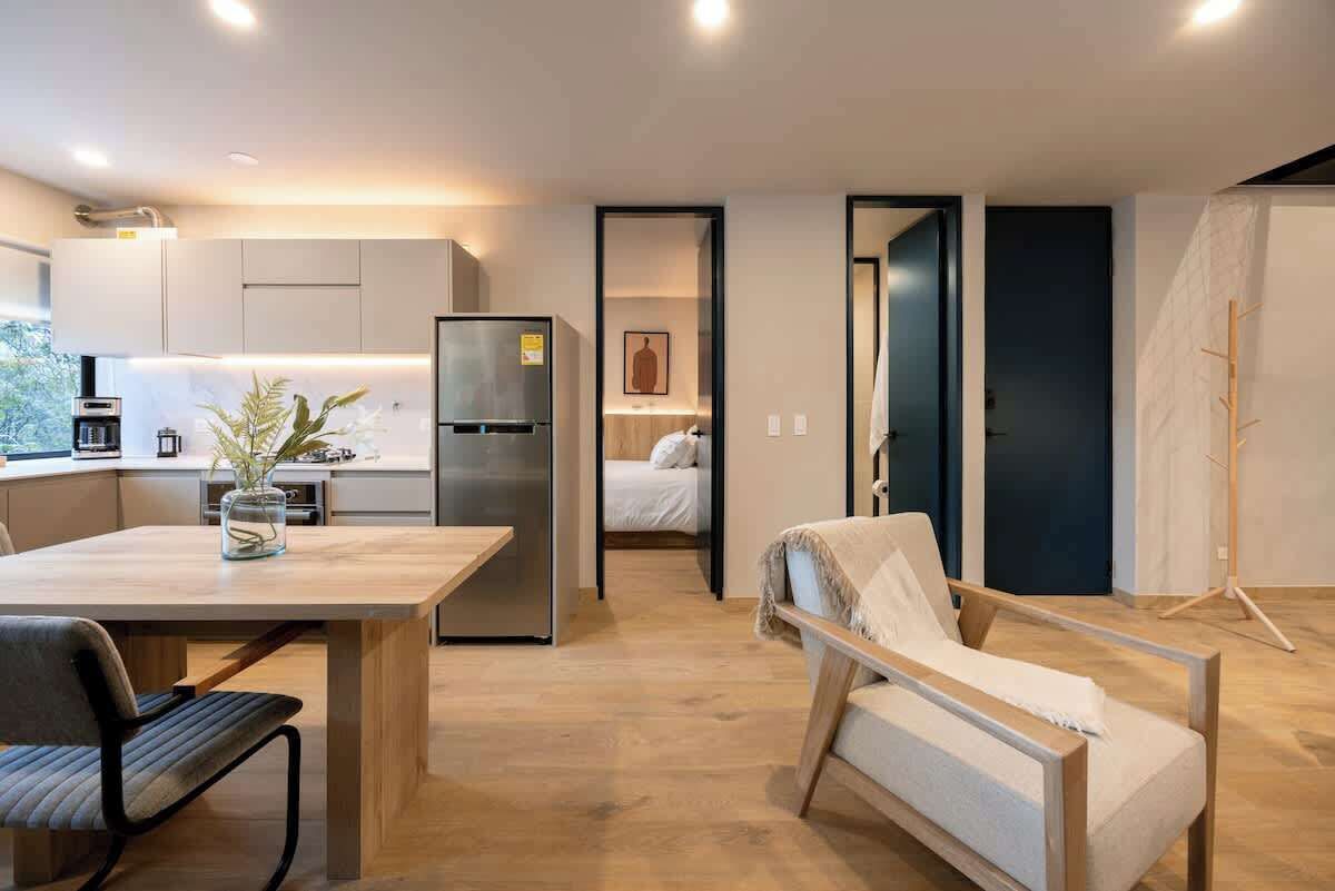 Un espace de vie moderne et compact comprenant une cuisine, un coin repas et un espace nuit confortable.