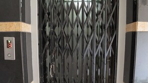 Ein schwarzes Metallgitter mit Rautenmuster, einer digitalen Anzeige und einem Zahlencodefeld.