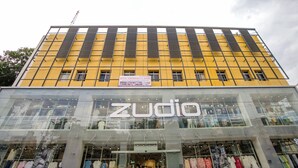 Ein Gebäude mit einer gelben Fassade, auf der der Schriftzug 'Zudio' gut sichtbar angebracht ist.