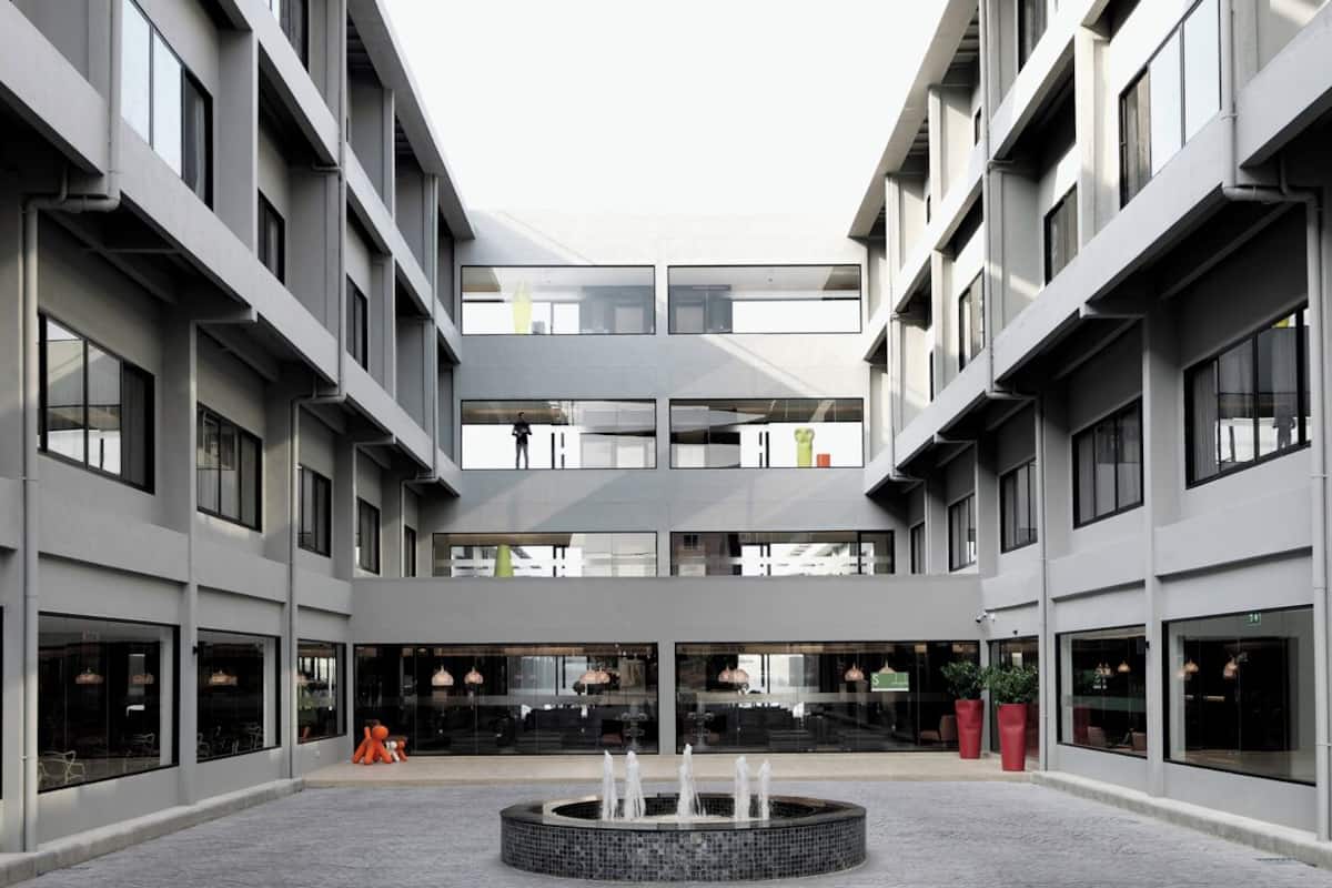 A modern building with a central courtyard, multiple floors, and large windows.