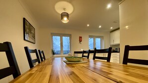 A dining room with a long wooden table, black chairs, and a bowl on the table.
