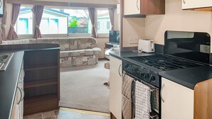 Une cuisine compacte équipée d’une cuisinière, d’un grille-pain et d’un coin repas avec un canapé.