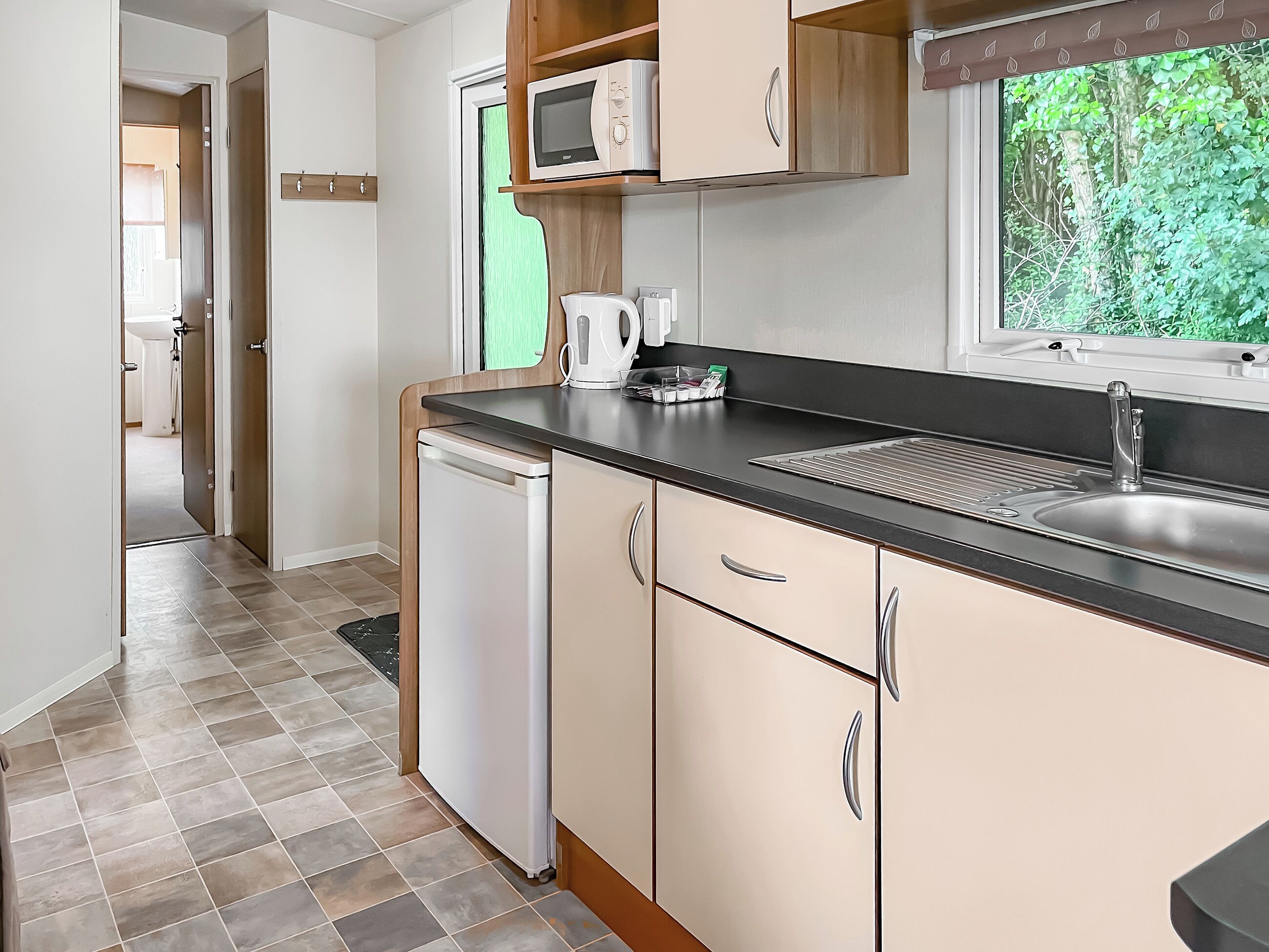 A modern kitchen with a dishwasher, a microwave, and a sink.