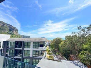 Ein modernes Gebäude mit mehreren Etagen, großen Fenstern und Blick auf eine gebirgige Landschaft.