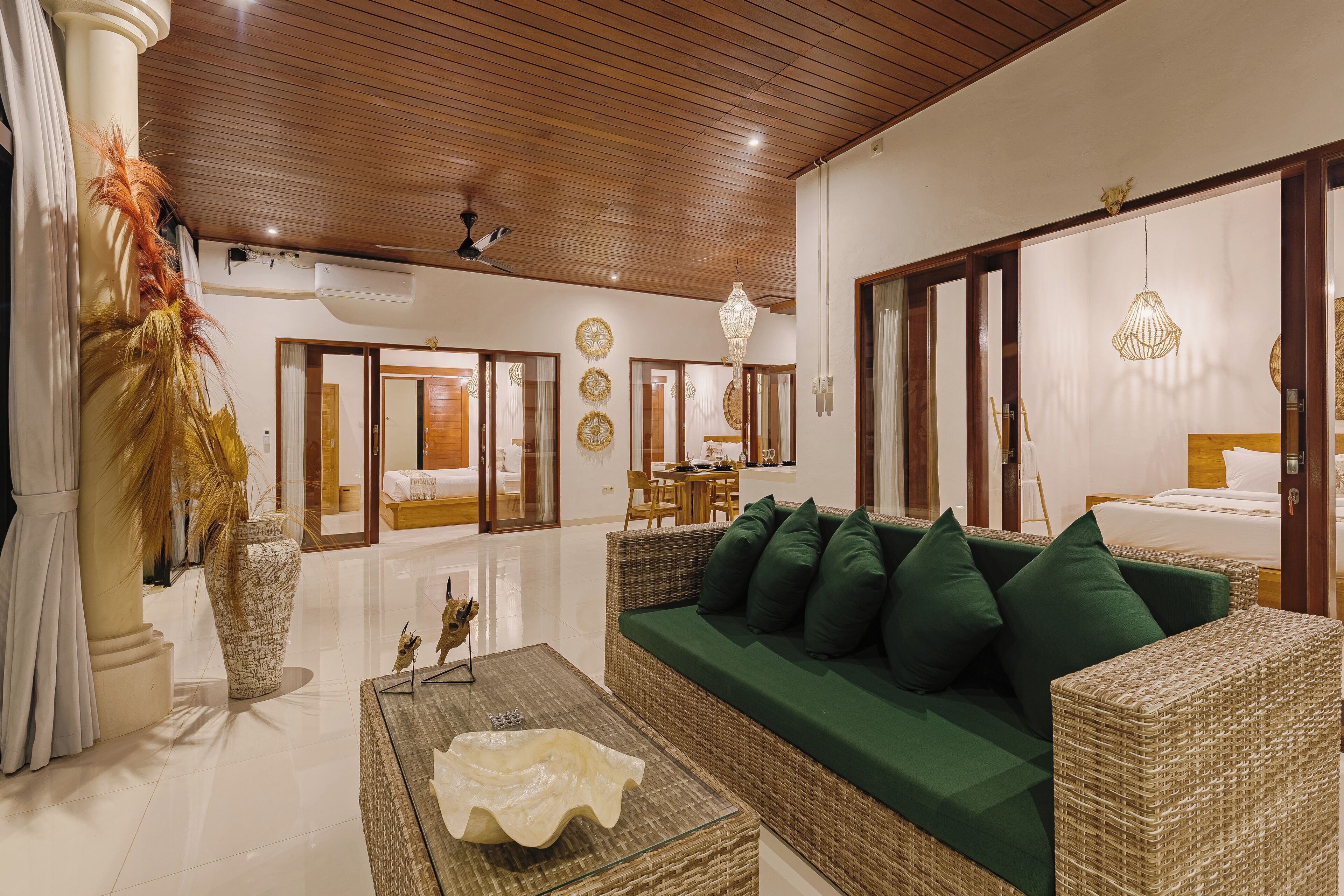 A spacious hotel lobby with a green sofa, a decorative vase, and a wooden ceiling.