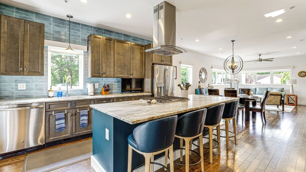 A modern kitchen with a central island, stainless steel appliances, and a view to the outdoors. - Near Solomons Island Boardwalk: Home w/ Hot Tub! (Solomons)