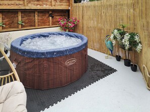 Un bain à remous avec une structure extérieure en bois et une étiquette indiquant « Lay-Z-Spa Toronto ».