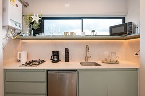 A modern kitchen with a built-in dishwasher, a coffee maker, and a microwave on the countertop.