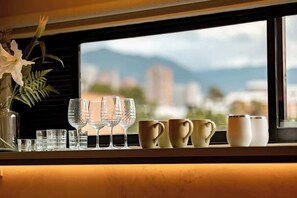 Una ventana con vista a un paisaje urbano y montañas.