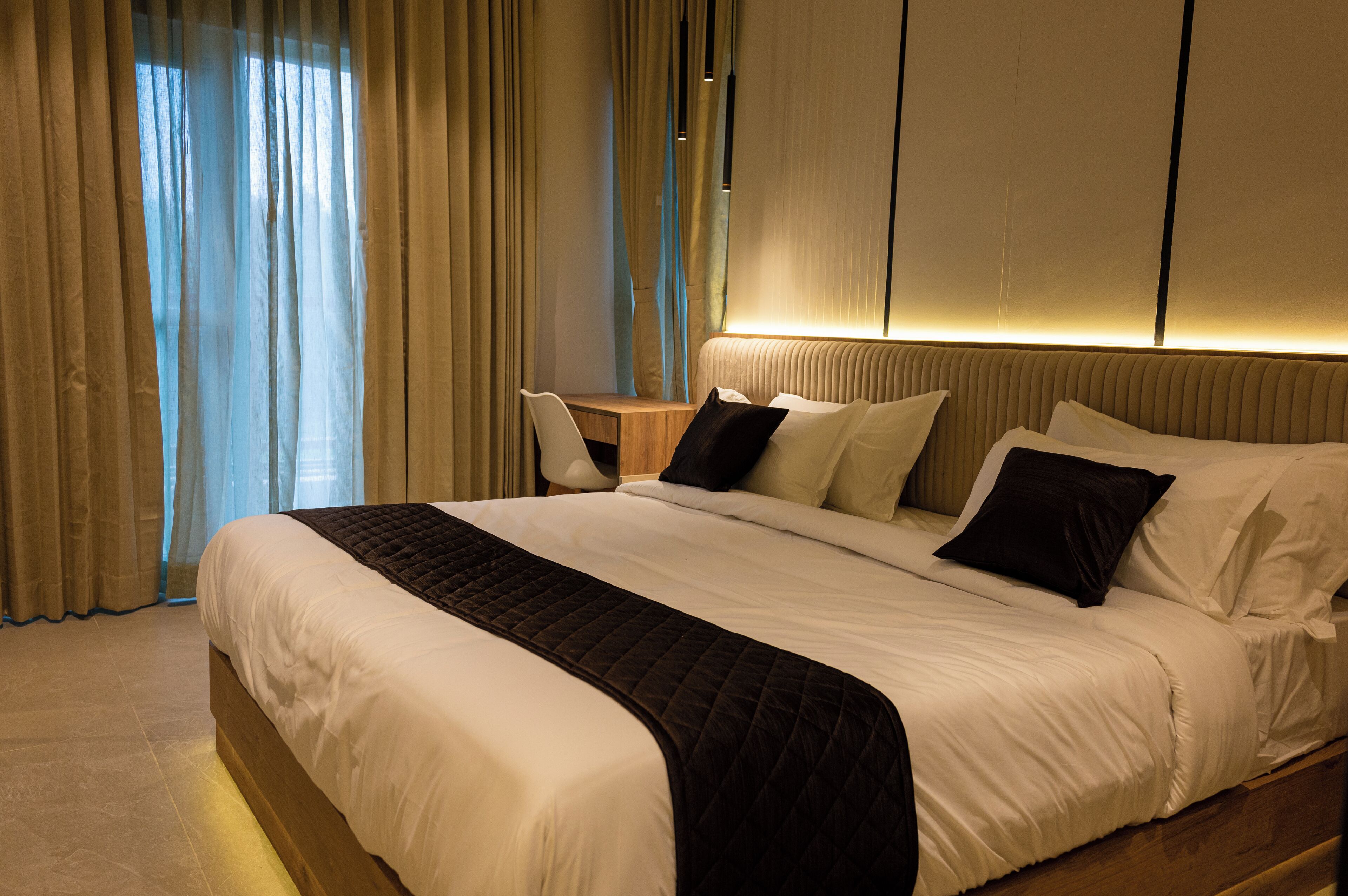 Habitació d'hotel amb un llit gran, una taula i una cadira.