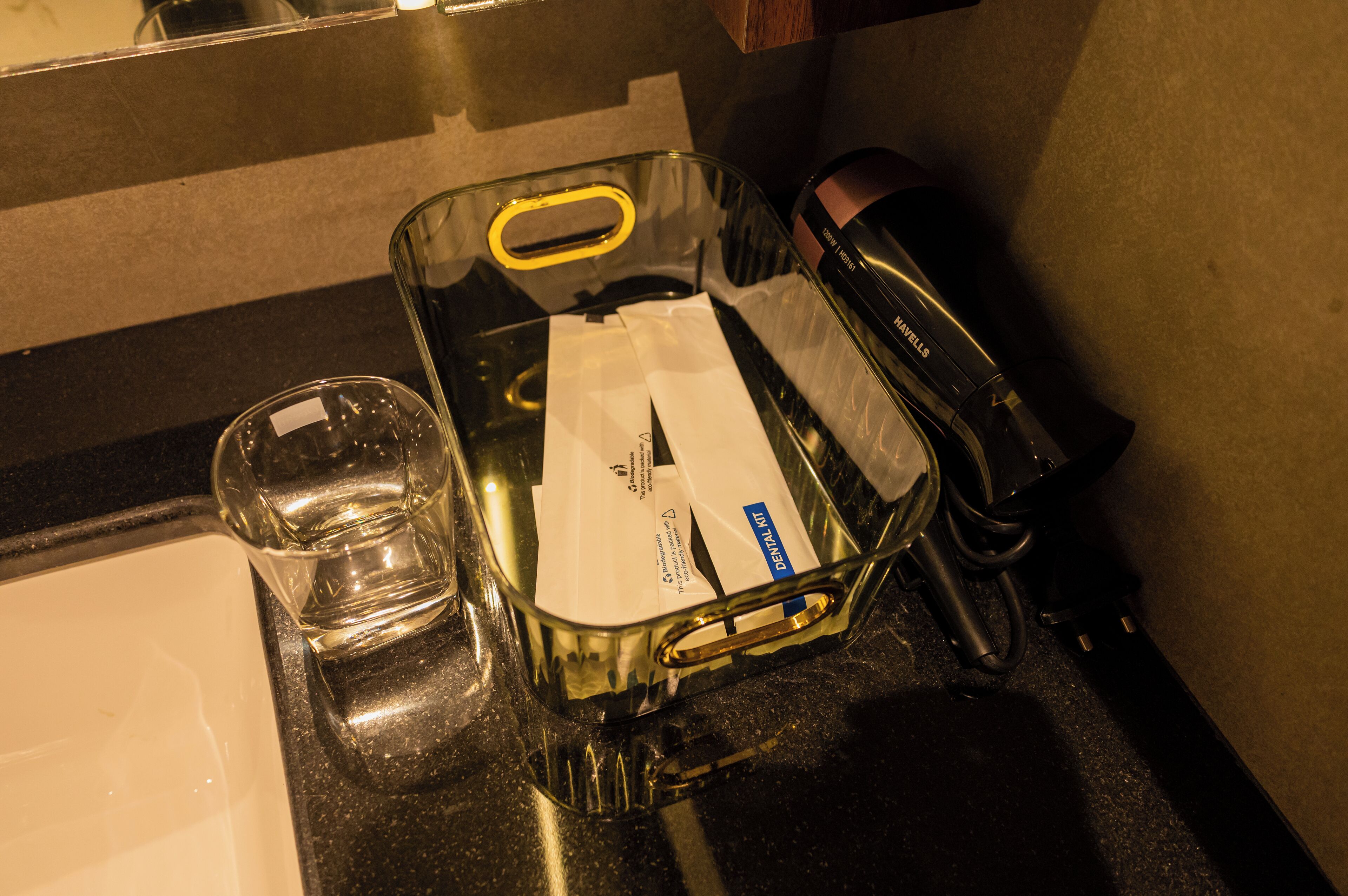 Ein Waschbecken mit einem Glas, einer Zahnbürste und einem Rasierer.