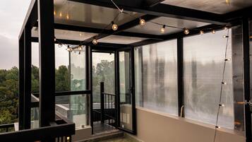 Ein modernes Interieur mit großen Fenstern, einem Balkon und Lichterketten.