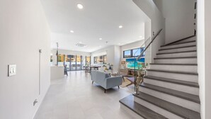 A modern interior with a staircase, a dining area, and a living room.