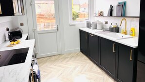 A modern kitchen with a built-in oven, a sink, and a window.