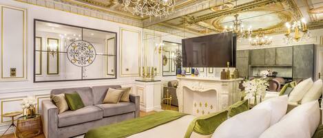 Ein luxuriöses Schlafzimmer mit einem großen Bett, einer Sitzecke, einem Kamin und einem Fernseher.