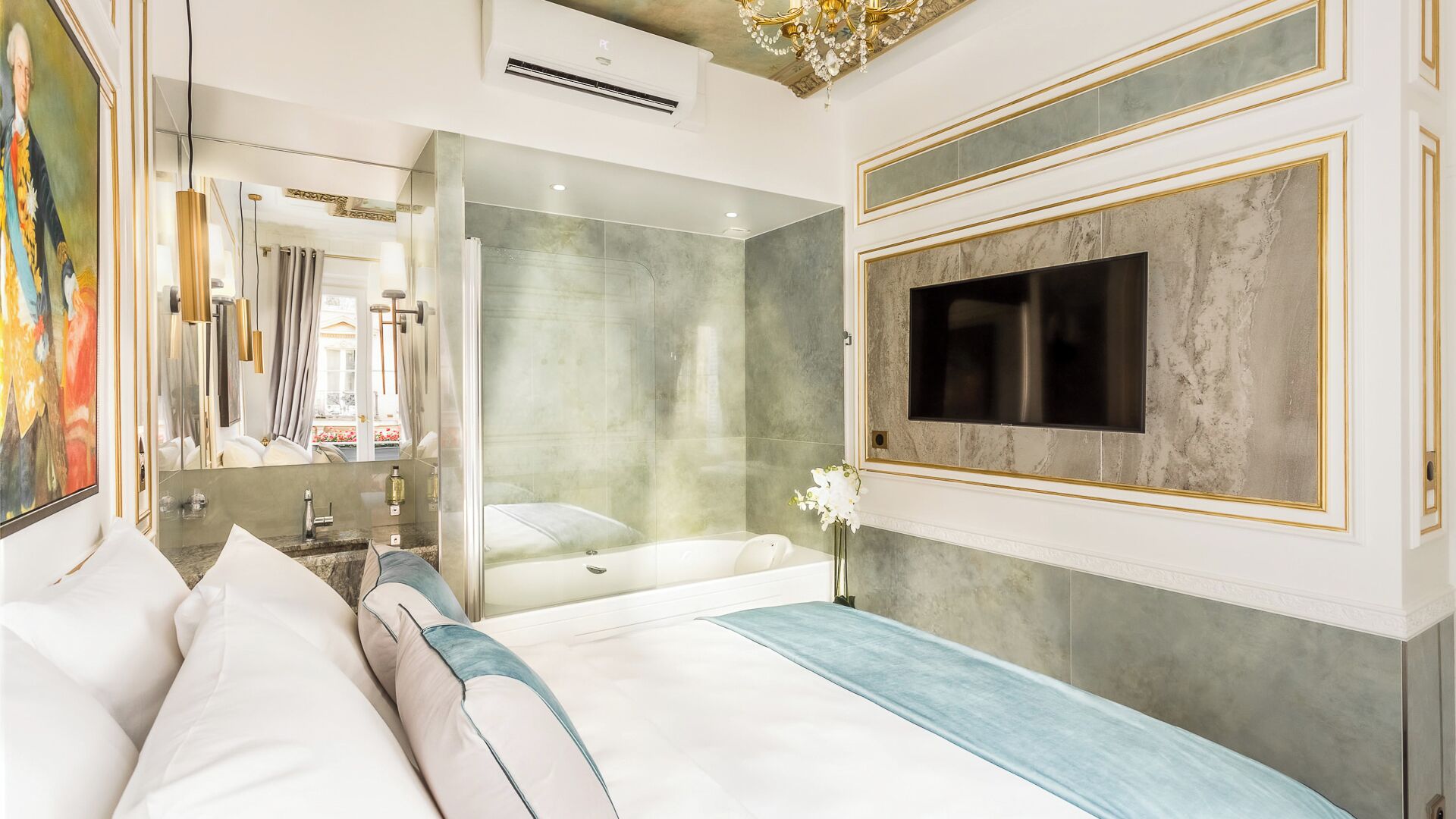 A modern hotel room with a large bed, a bathtub, a shower, and a TV mounted on the wall.