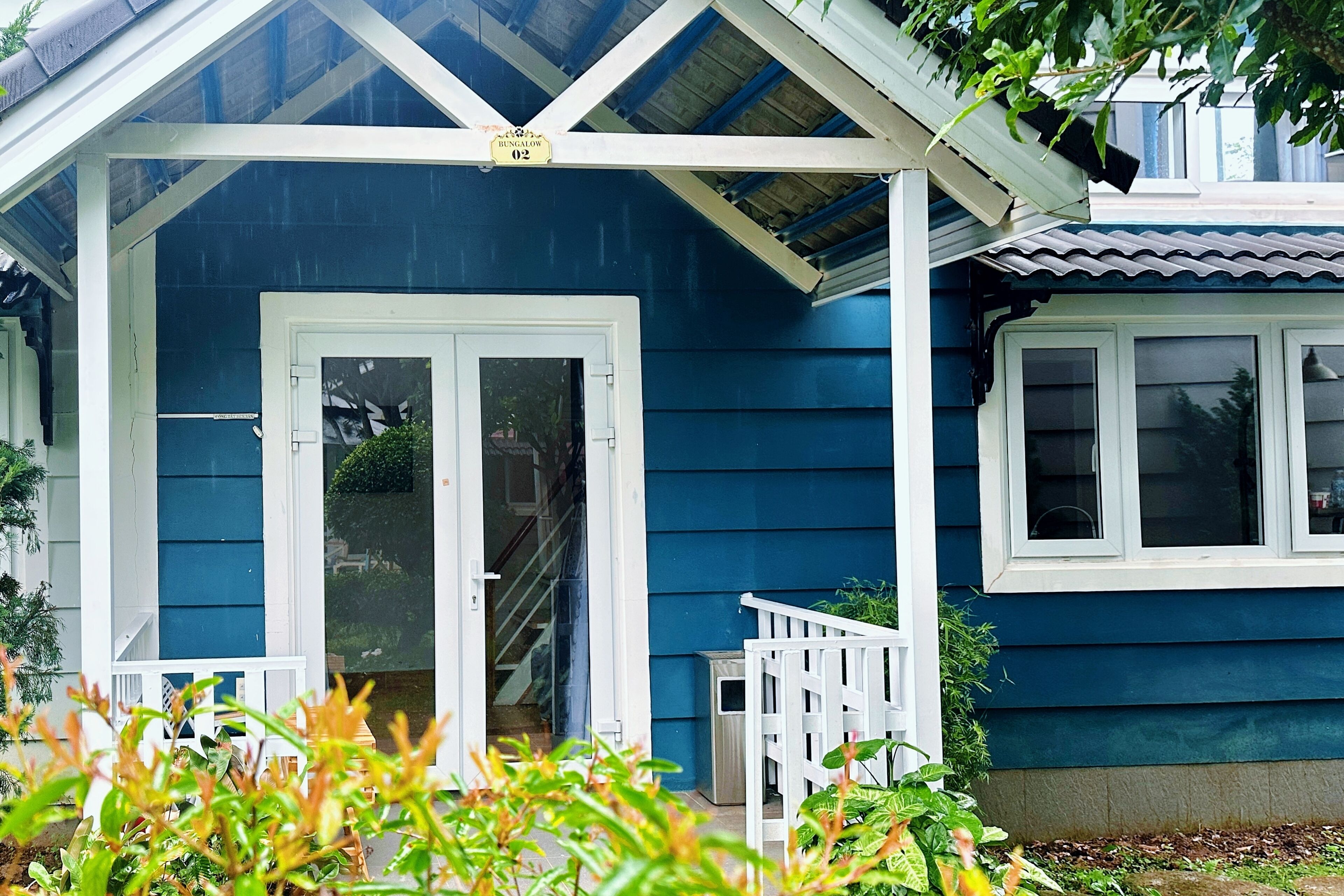 Ein blaues Haus mit einer Veranda und einer weißen Tür.