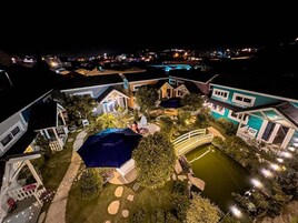 Uma maquete de uma área residencial com casas, uma ponte e um lago pequeno.