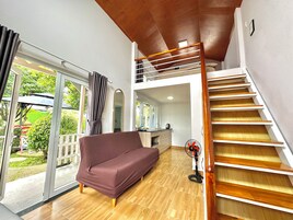 Um interior moderno com escada de madeira, sofá e varanda com portas de vidro.