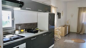 A modern kitchen with a stove, sink, and cabinets. - GÎTES TERRA DI A BRAVONA (Linguizzetta)