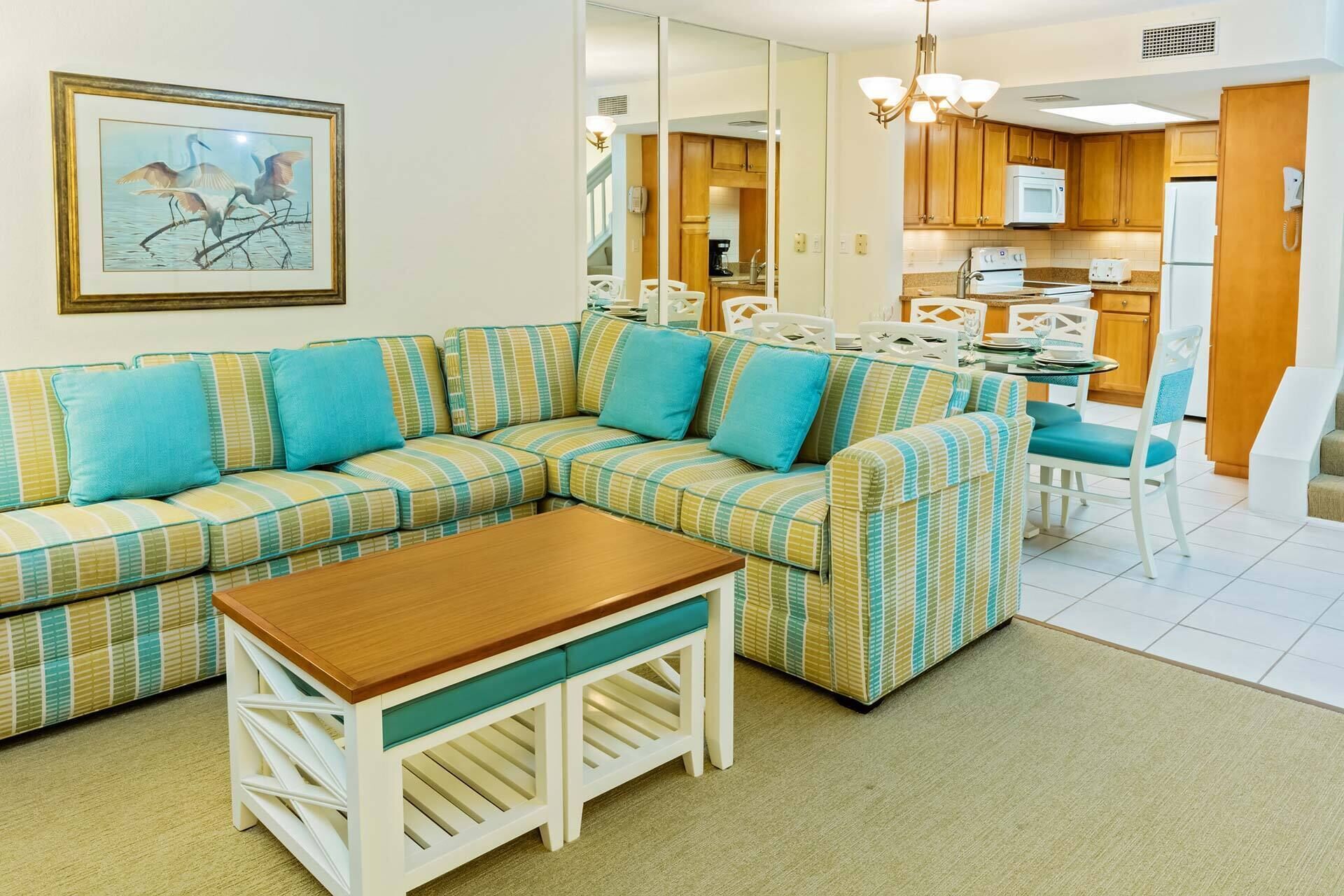 A living room with a sectional sofa, a coffee table, and a dining area with a table and chairs.