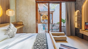 Un dormitorio moderno con una cama grande, un banco de madera, un televisor y vistas a una piscina y zona exterior.