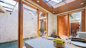 Una cocina moderna con pared de piedra, techo de madera y un ventanal grande.