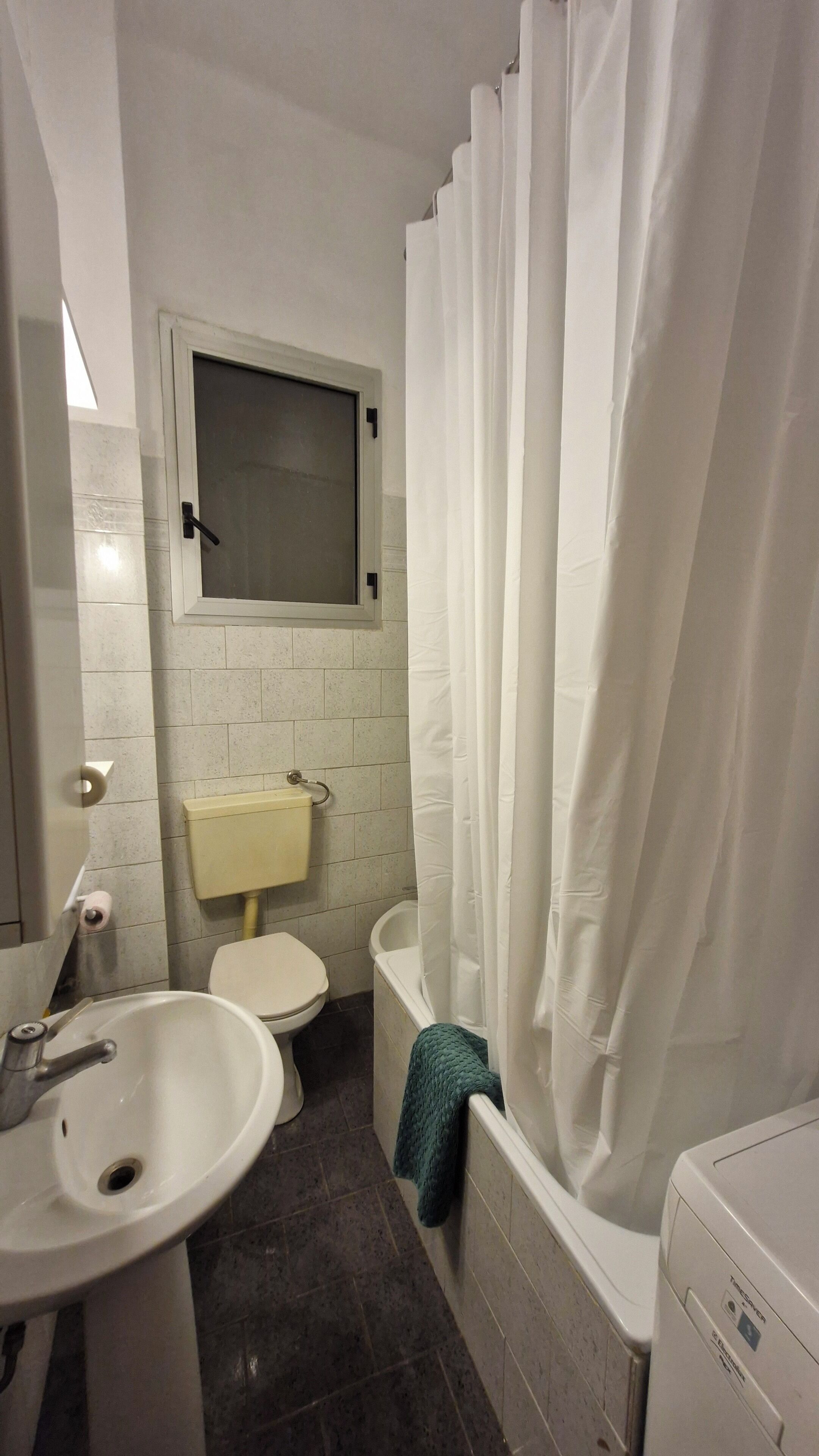 A small bathroom with a toilet, sink, and bathtub.