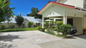 A building with a covered outdoor area, a parking space, and a clear blue sky.