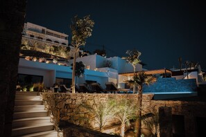 Um edifício moderno com uma escadaria de pedra que leva a um terraço com área de estar ao ar livre.