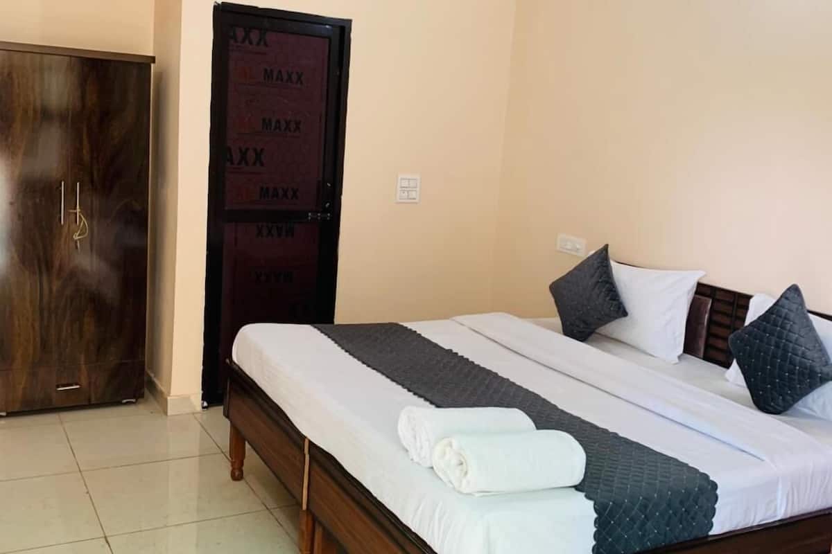 A bedroom with a wooden bed, a wardrobe, and a door with a nameplate.