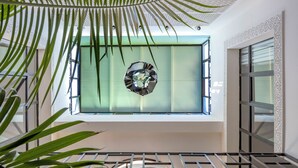 Un interno moderno con un'ampia finestra, un elemento decorativo circolare e un soffitto con motivo geometrico.
