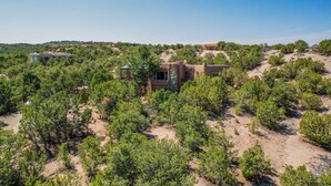 A desert landscape with a modern building surrounded by dense green vegetation.