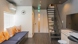 Una habitación de hotel moderna con cama, escalera y kitchenette.