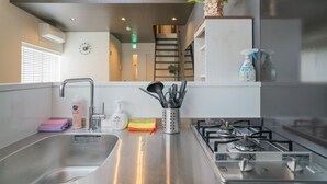Una cocina moderna con electrodomésticos de acero inoxidable, un fregadero y diversos utensilios de cocina.