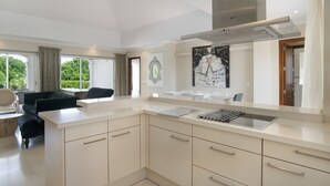 Een moderne keuken met een groot schiereiland, inbouwapparatuur en uitzicht op de omgeving.